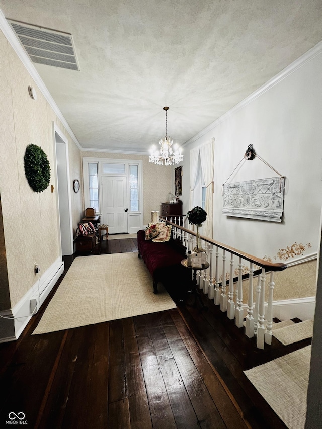 entrance foyer with visible vents, baseboards, hardwood / wood-style floors, and crown molding