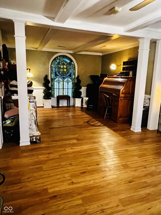 dining room featuring decorative columns, beamed ceiling, and wood finished floors