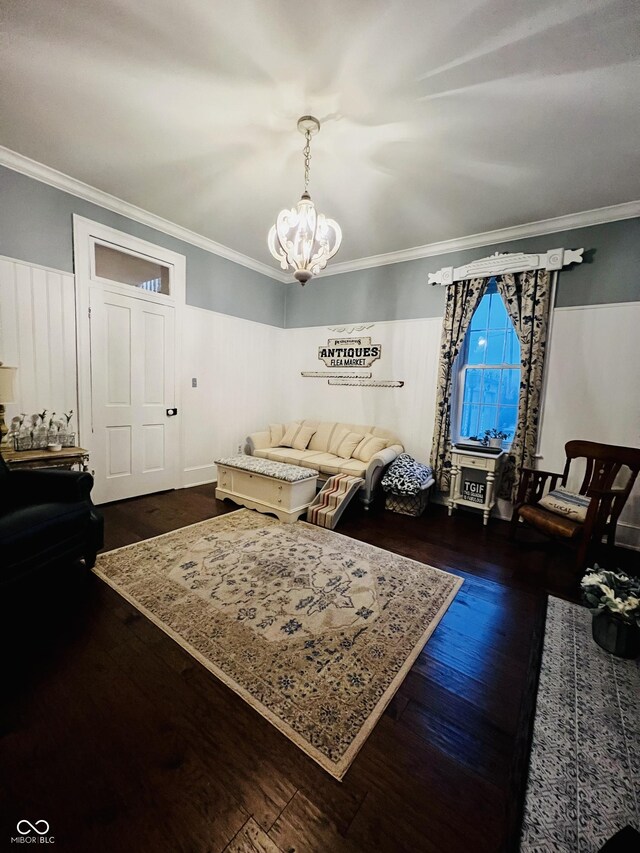 living room with dark wood finished floors, crown molding, and a chandelier