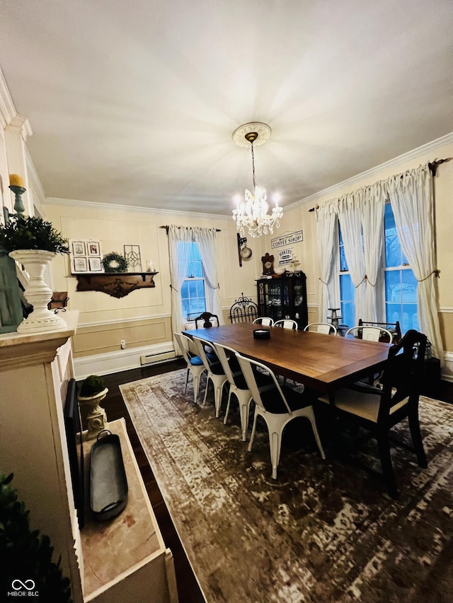 dining space with a decorative wall, a notable chandelier, wood finished floors, and ornamental molding