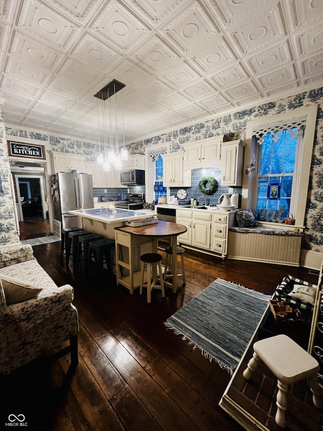 kitchen featuring dark wood finished floors, appliances with stainless steel finishes, and an ornate ceiling