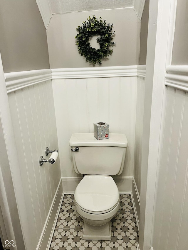 bathroom featuring toilet and wainscoting