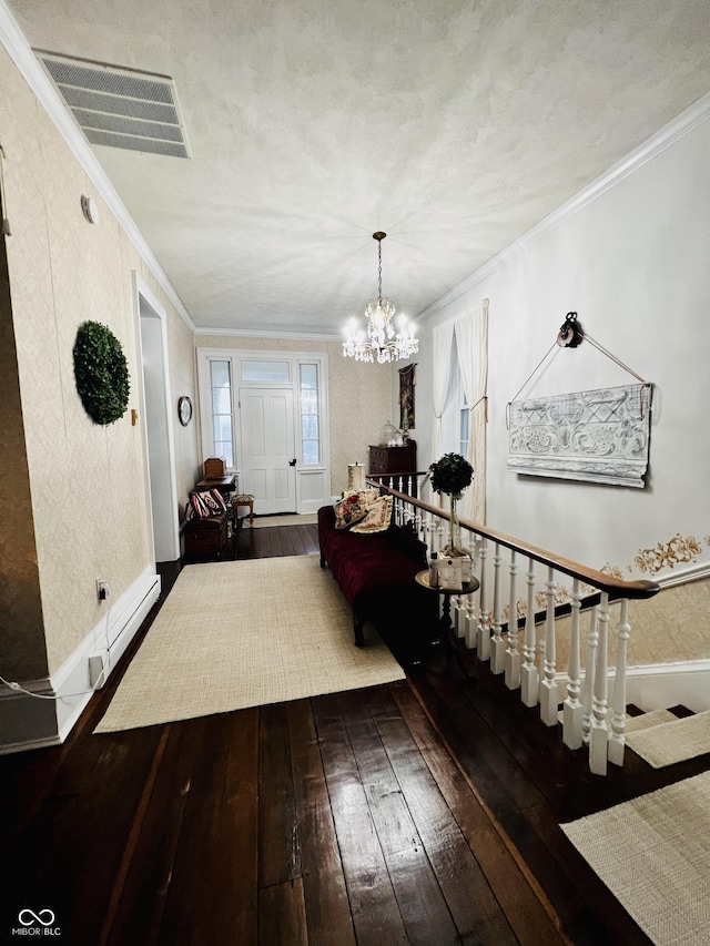 entrance foyer with visible vents, baseboards, hardwood / wood-style floors, and ornamental molding