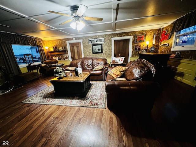 living area featuring wallpapered walls, a ceiling fan, and wood finished floors