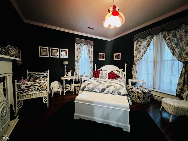 bedroom featuring visible vents, crown molding, and wood finished floors