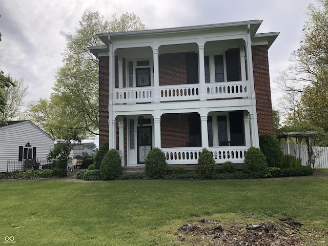 view of front of house featuring brick siding, a porch, and a front lawn