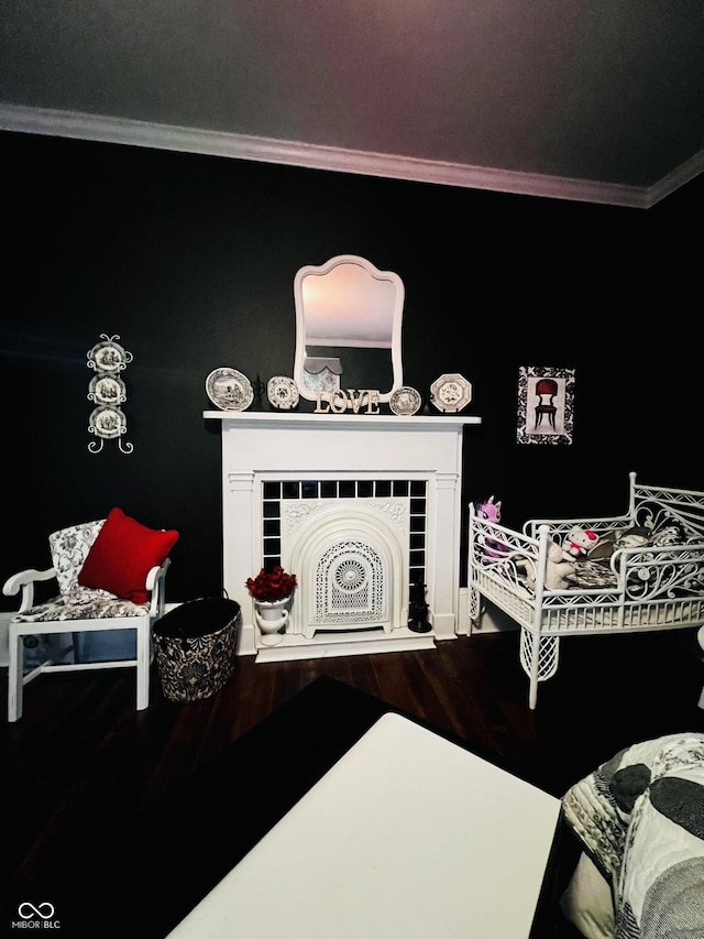 interior space featuring crown molding, wood finished floors, and a tile fireplace