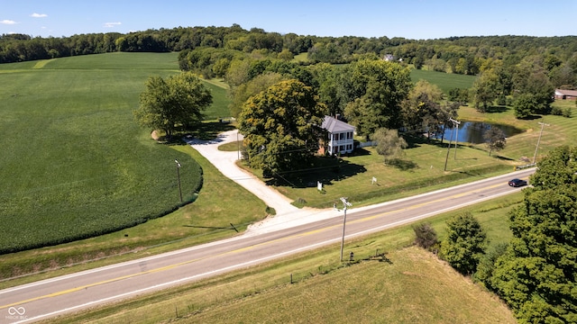 drone / aerial view featuring a rural view, a view of trees, and a water view