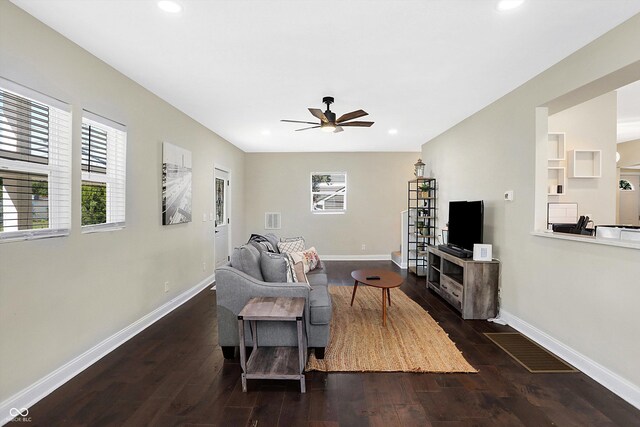 living room featuring ceiling fan and dark hardwood / wood-style floors