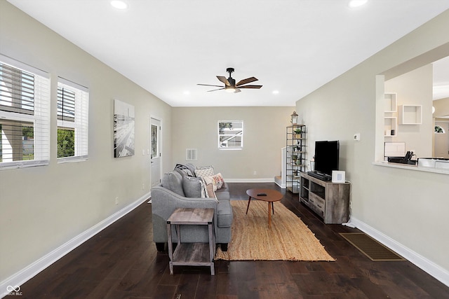 living area with visible vents, baseboards, and a ceiling fan