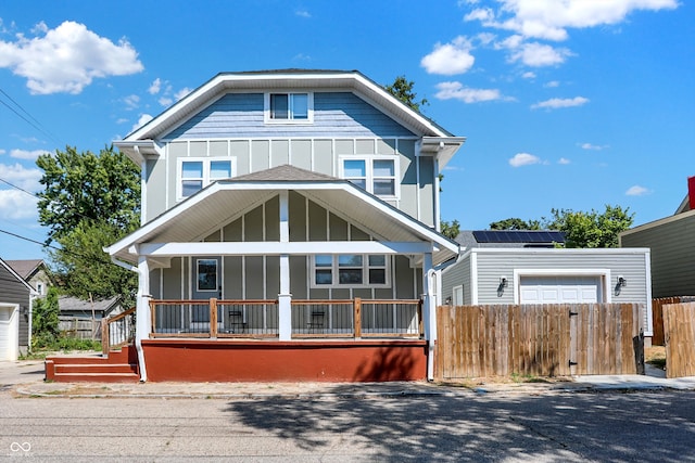 view of front of home featuring a porch, a garage, and solar panels