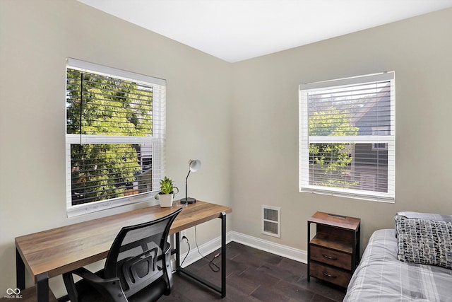 office space with a wealth of natural light, heating unit, baseboards, and dark wood-type flooring