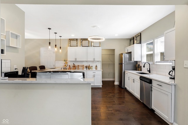 kitchen featuring light stone counters, stainless steel appliances, dark hardwood / wood-style flooring, sink, and decorative backsplash