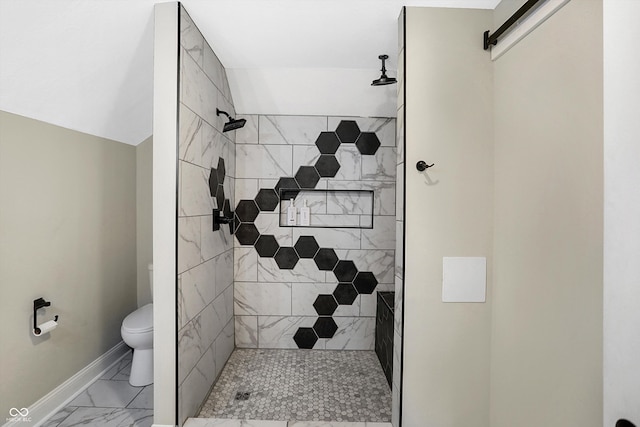 bathroom featuring lofted ceiling, tiled shower, and toilet