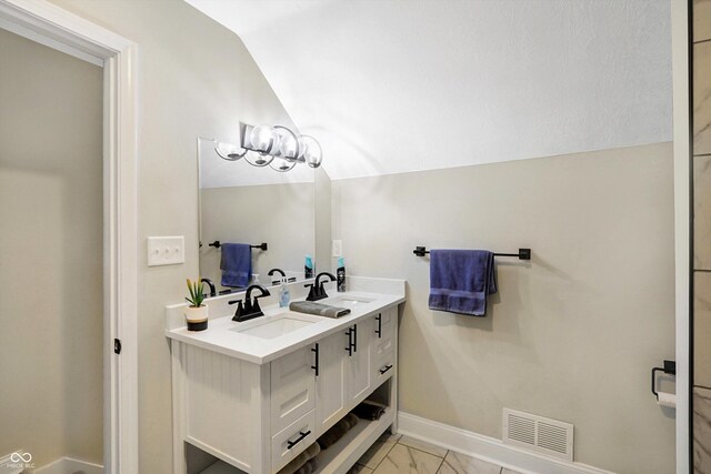 bathroom with vaulted ceiling and vanity