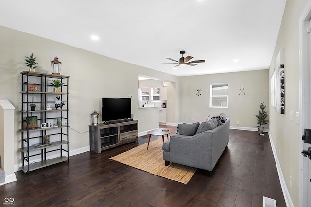 living room featuring dark wood-type flooring and ceiling fan