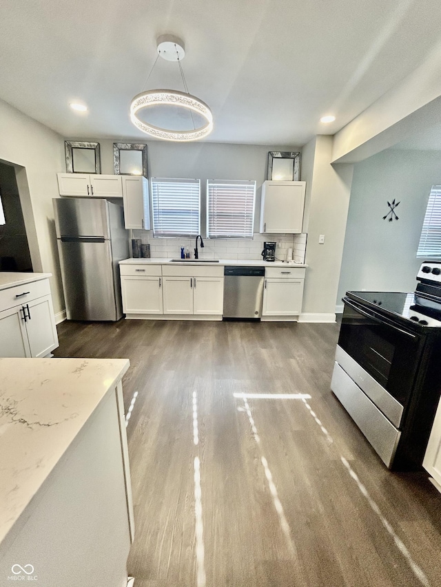 1938 E 11th St, Indianapolis, IN 46201 - kitchen with stainless steel appliances, dark wood-type flooring, a sink, white cabinets, and baseboards