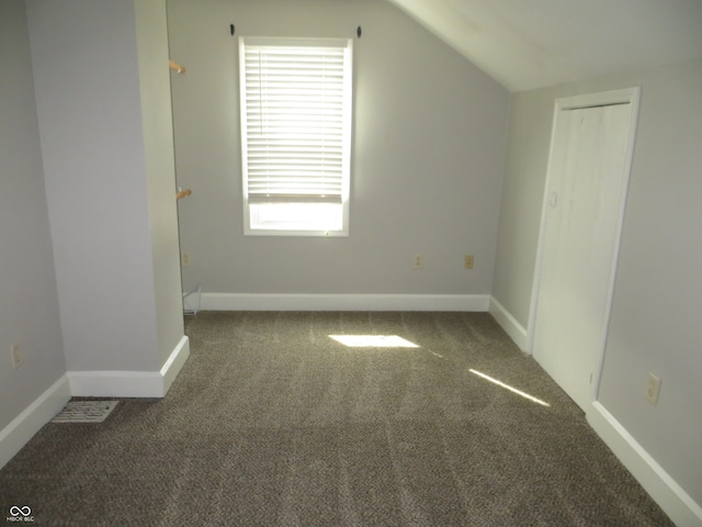 additional living space featuring lofted ceiling and carpet flooring