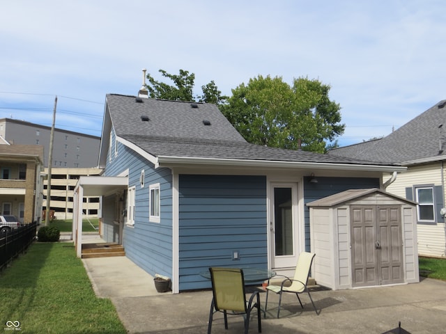 rear view of property with a storage shed and a patio area