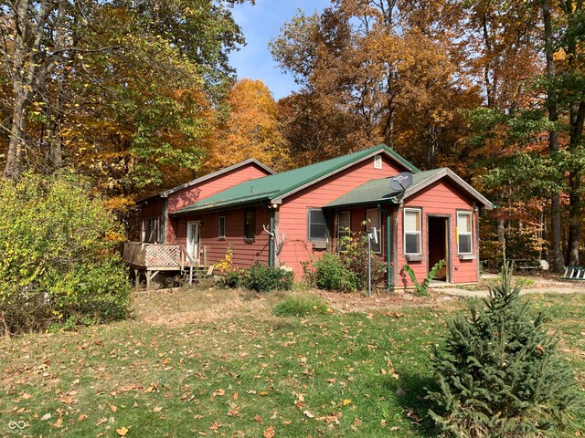 view of front of home with a front yard and a wooden deck