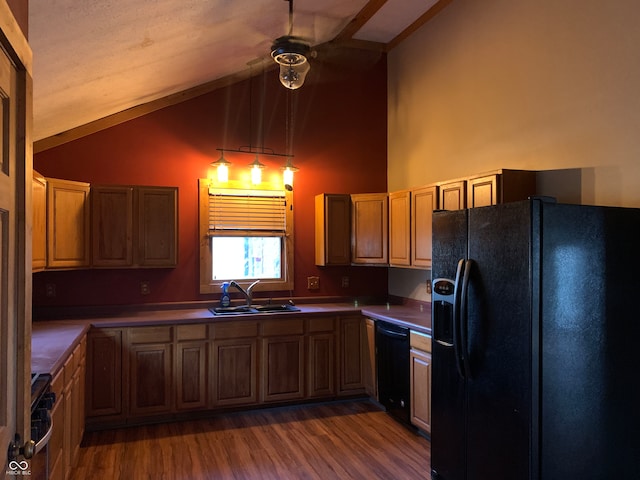 kitchen featuring black appliances, wood-type flooring, pendant lighting, sink, and lofted ceiling