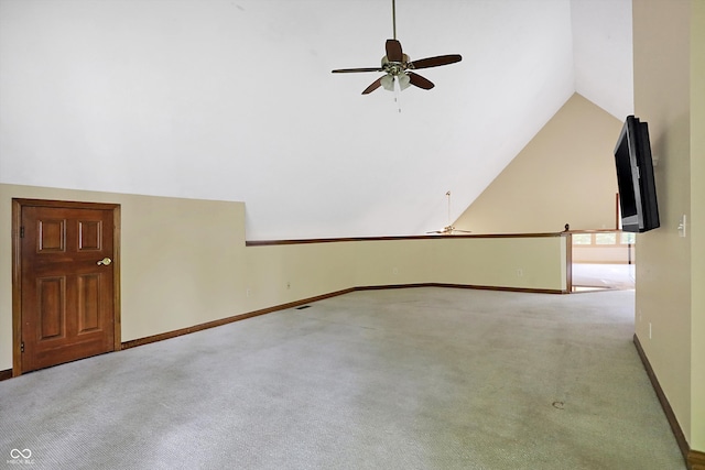 unfurnished living room with ceiling fan, light colored carpet, and lofted ceiling