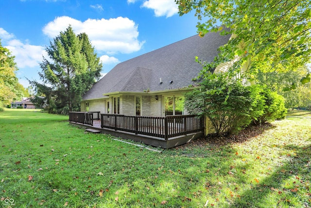 back of house with a deck and a lawn