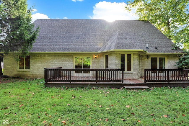 rear view of property with a wooden deck and a yard