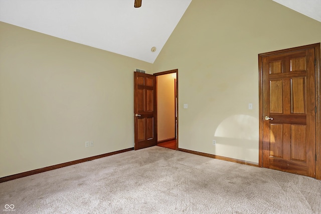 unfurnished room with light carpet and high vaulted ceiling