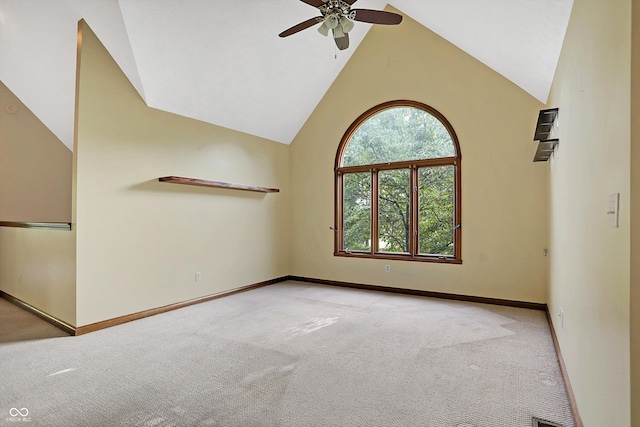 spare room featuring light carpet, vaulted ceiling, and ceiling fan