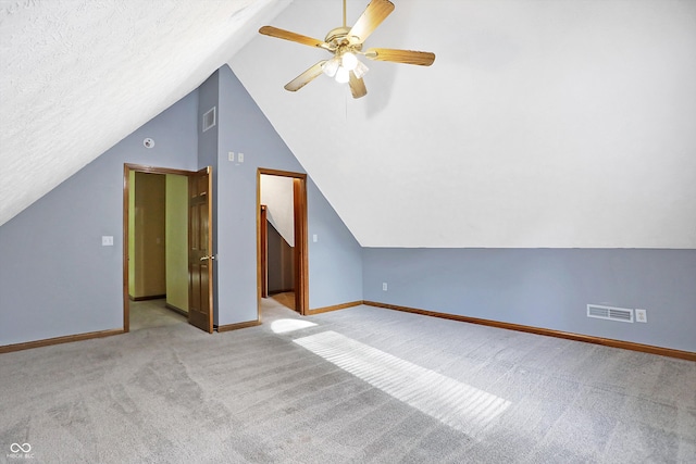 bonus room featuring light carpet, a textured ceiling, vaulted ceiling, and ceiling fan