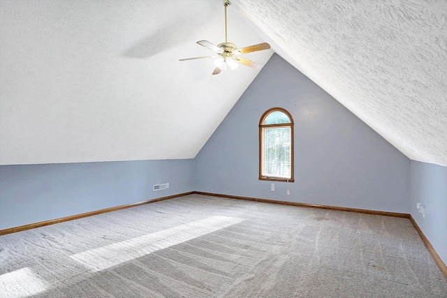 bonus room with a textured ceiling, ceiling fan, light colored carpet, and vaulted ceiling