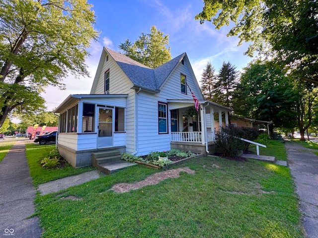 view of front of property featuring a sunroom and a front lawn