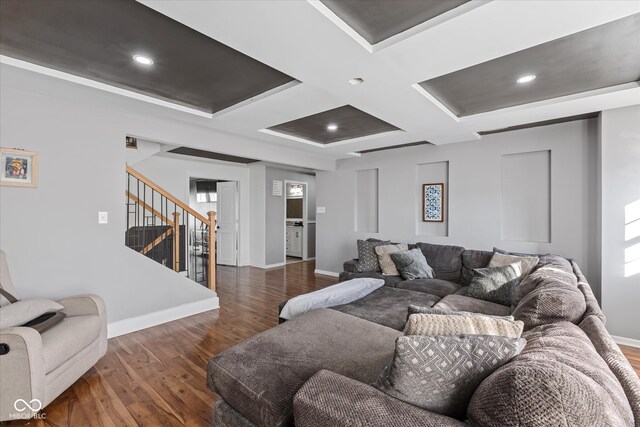 living room featuring coffered ceiling and dark hardwood / wood-style floors