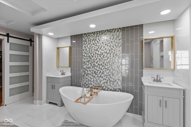 bathroom featuring a washtub, vanity, tile patterned flooring, and tile walls