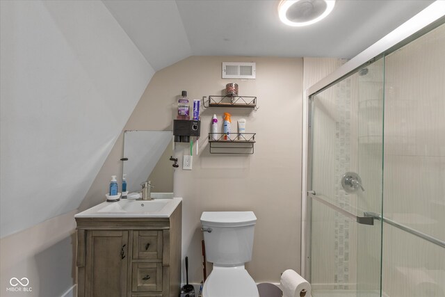 bathroom with a shower with door, vanity, lofted ceiling, and toilet