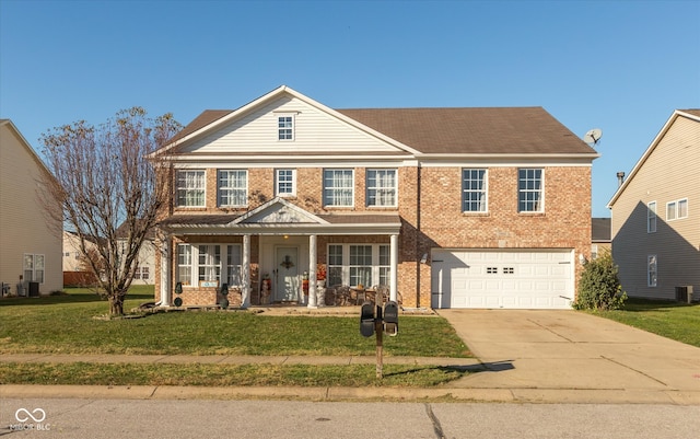 view of front of house with a front lawn, central AC unit, and a garage