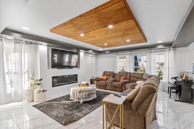 living room with a raised ceiling and wooden ceiling