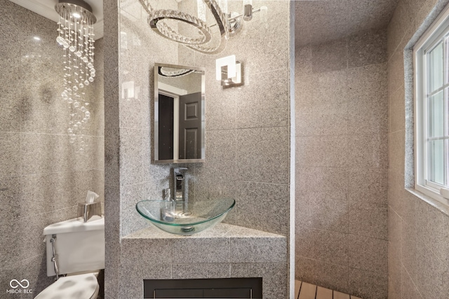 bathroom with vanity, tile walls, and toilet