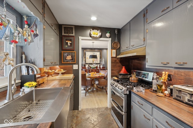 kitchen featuring double oven range, sink, gray cabinetry, and wood counters