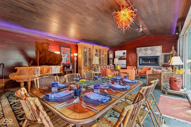 dining space with wood ceiling, a fireplace, and vaulted ceiling