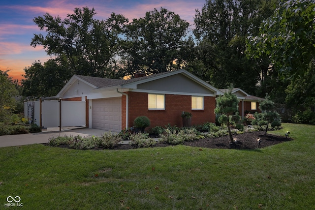 ranch-style house with a garage and a lawn