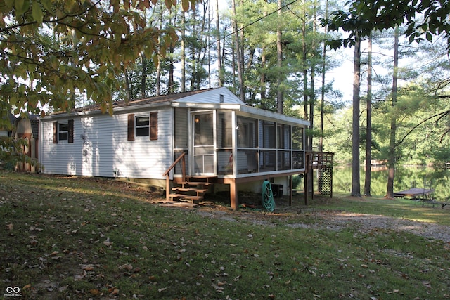 back of property featuring a lawn and a sunroom