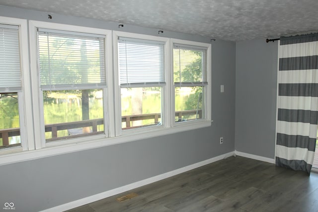 unfurnished room with a wealth of natural light and dark hardwood / wood-style floors