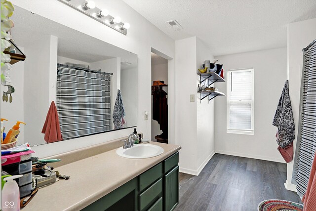 bathroom featuring vanity, a textured ceiling, and hardwood / wood-style flooring