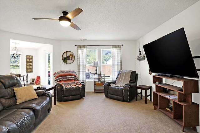 carpeted living room with a textured ceiling and ceiling fan with notable chandelier