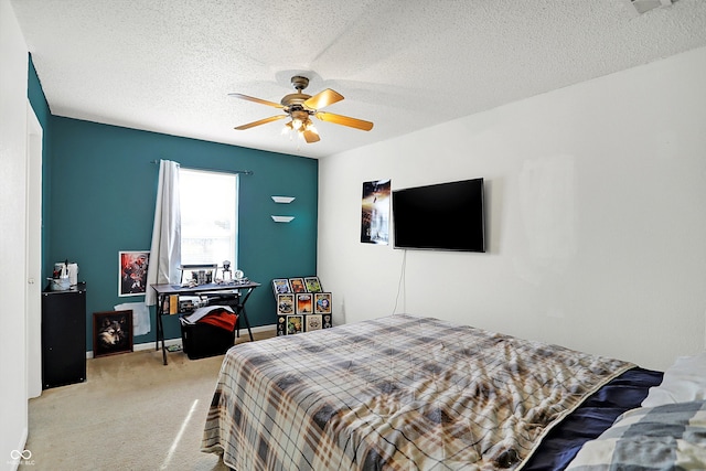 bedroom featuring a textured ceiling, light colored carpet, and ceiling fan