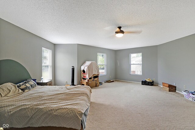 carpeted bedroom with ceiling fan and a textured ceiling