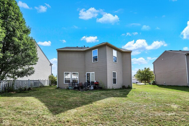 rear view of property featuring a lawn