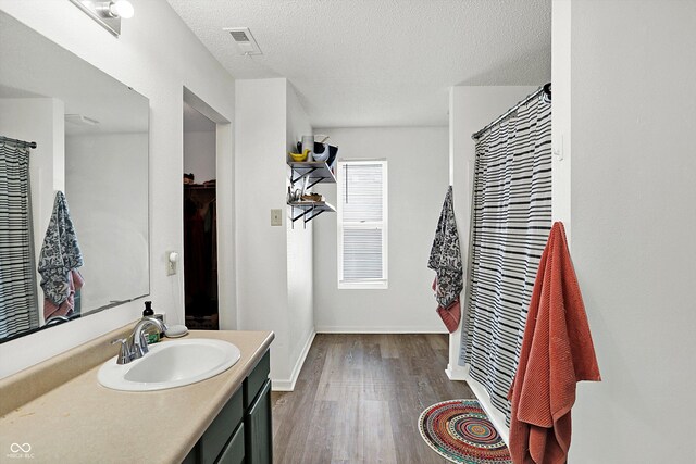 bathroom featuring hardwood / wood-style floors, vanity, and a textured ceiling